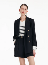 a lady in black blazer with black shorts and striped top